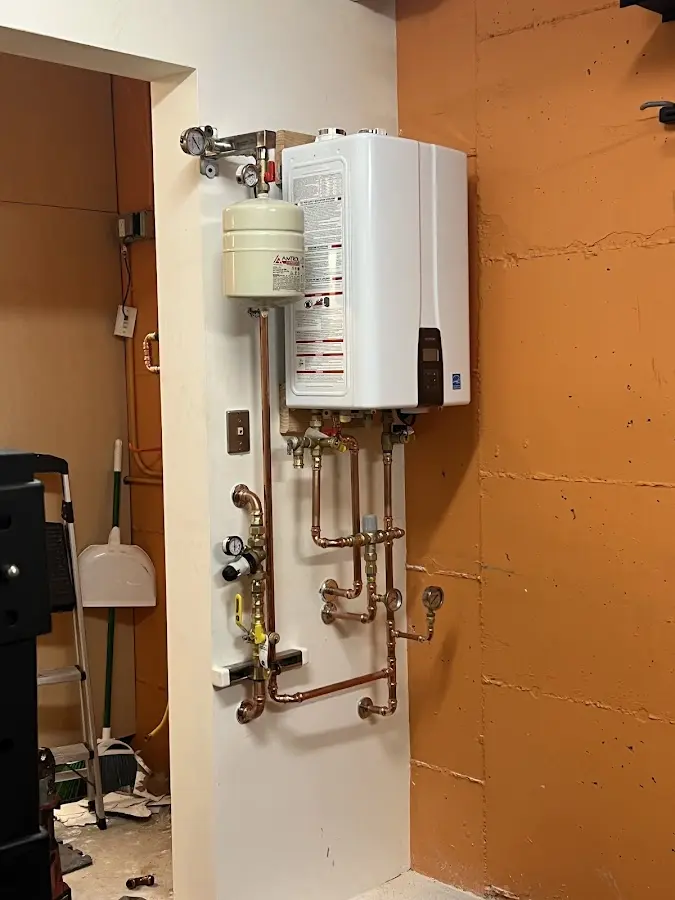 Plumbing technician inspecting water heater connections in Burleson